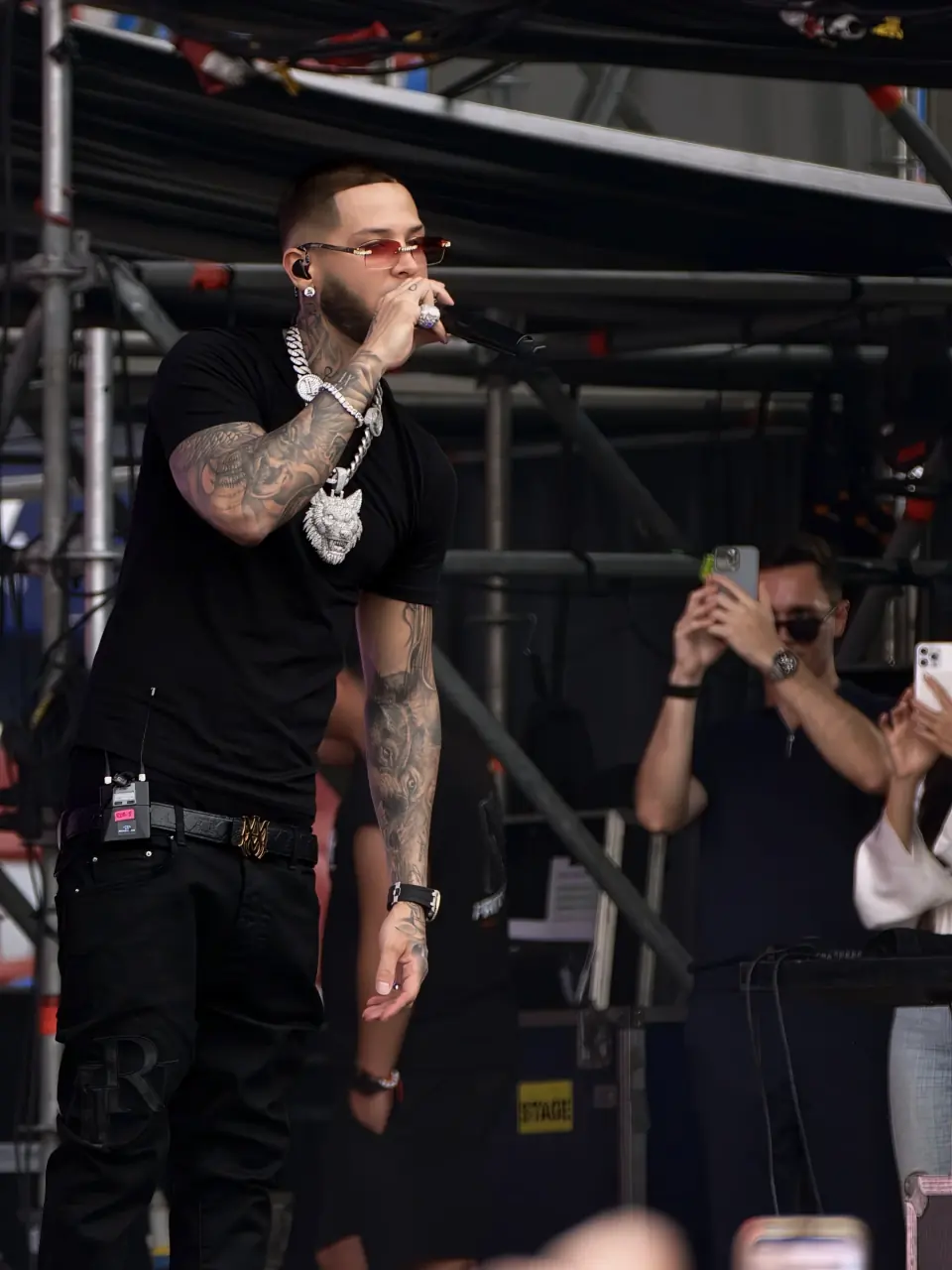 Cantante de Latin Fest actúa con gafas rojas y micrófono durante la primera jornada