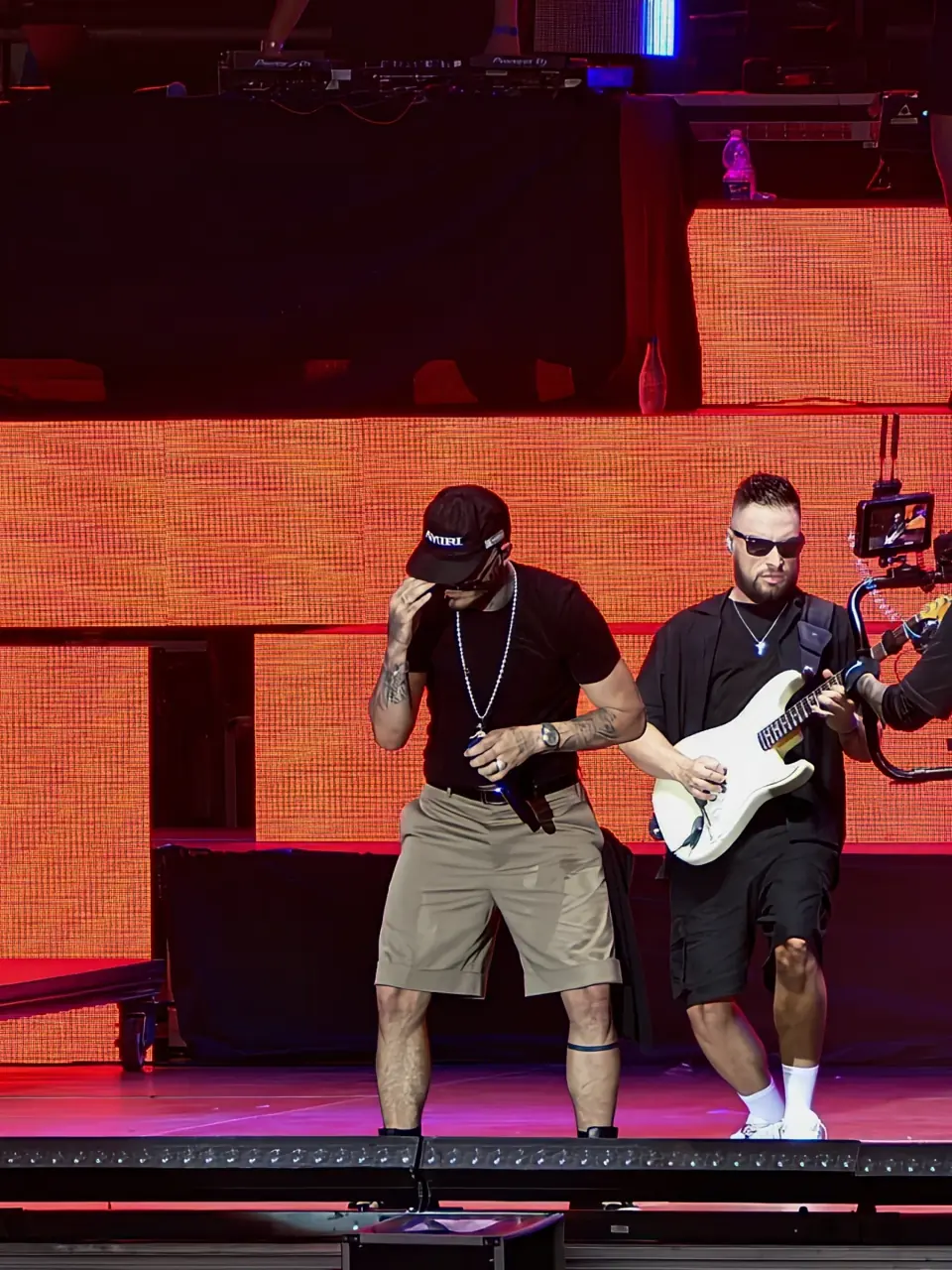 Cantante y guitarrista actúan bajo iluminación roja en la segunda jornada de Latin Fest